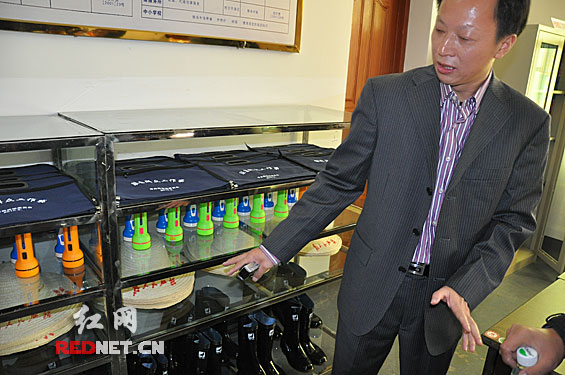 衡阳县委书记肖顺生向记者介绍驻村干部的必备工具:自行车,草帽,手