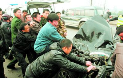 车祸现场,群众,消防,交警和巡特警等20余人一起用绳索拉开车体,救出车