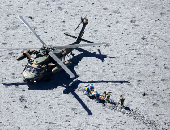 图为向自卫队直升机搬送登山客的自卫队员和警察