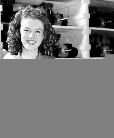 名叫诺玛·琼·贝克的女工在机器边生产的健美身姿.