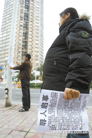 張邦祥和懷孕九個月的妻子在街上貼尋人啟事 記者 吳子敬 攝本報訊