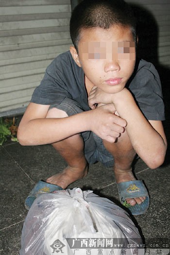 在官塘市场外流浪多日的男孩.记者 冯革里摄