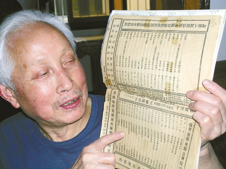 图为郑挥正翻开他收藏的老电话簿.(南 华 摄)