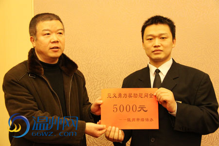 张建树将5000元慰问金亲手交到郭小亮手上 .郭欢欢/摄