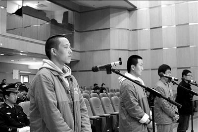 四男子涉嫌非法经营受审。本报记者欧阳晓菲摄