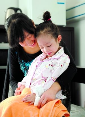 昨日,在八一儿童医院,"大肚女孩"胡云星被妈妈逗乐了.