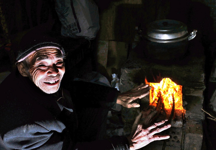 图文:76岁的陶大爷早已习惯生火取暖