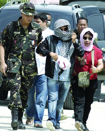 日,在菲律宾马京达瑙省,警方押解菲律宾达都温赛市市长小安帕图安(中)