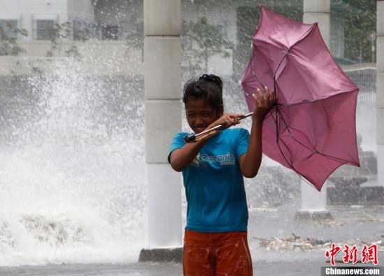 5月9日,菲律宾马尼拉,在热带风暴艾利带来的强风暴雨下,一名女 