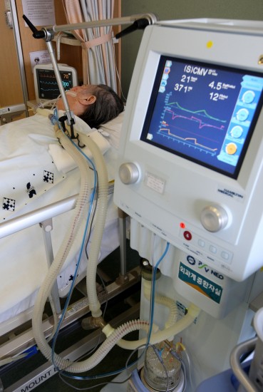 6月23日在韩国首尔一家医院内拍摄的77岁的患者在被摘除呼吸机之前的