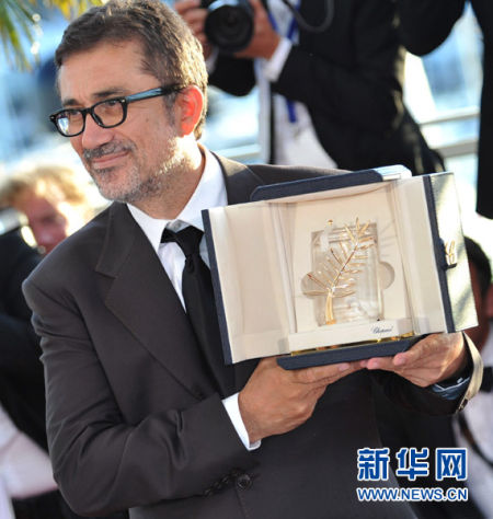举行的第67届戛纳电影节上,土耳其导演努里·比尔盖·杰伊兰展示奖杯