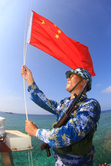 资料图:驻守在南沙岛礁的海军战士在升国旗