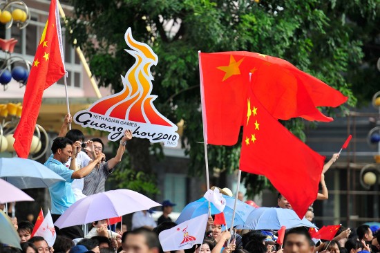 图文广州亚运会火炬传递汕尾站群众挥舞国旗助兴