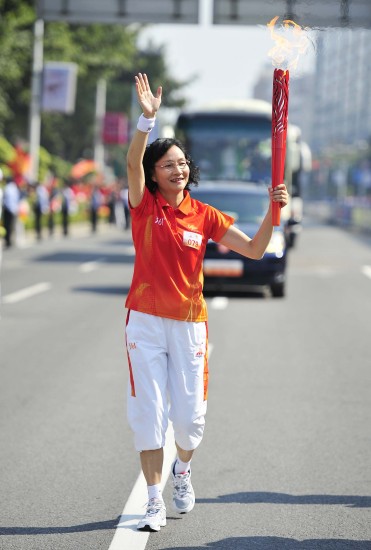 图文广州亚运会火炬在肇庆传递陈以良挥手慢跑